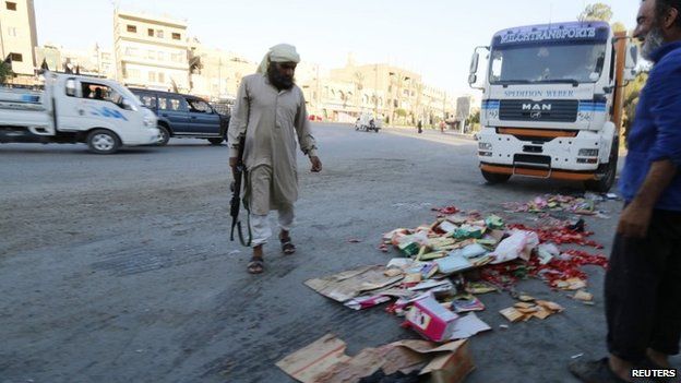 Islamic State fighter throws confiscated goods away in Raqqa, Syria (14 August 2014)