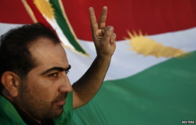 A man gestures in front of the flag of Kurdistan at a demonstration in Athens, Greece (13 October 2014)