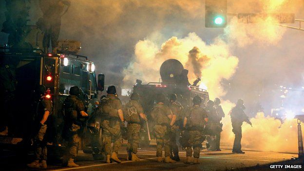 Riot police on 18 August 2014 face off with protesters angered by the killing of a black teenager by a white policeman in Ferguson, Missouri.