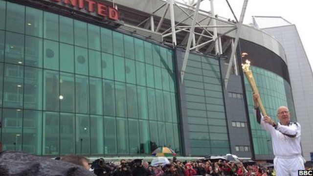 Sir Bobby Charlton outside Old Trafford with the Olympic flame