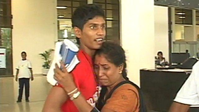 Sri Lankan woman greeting son with hug