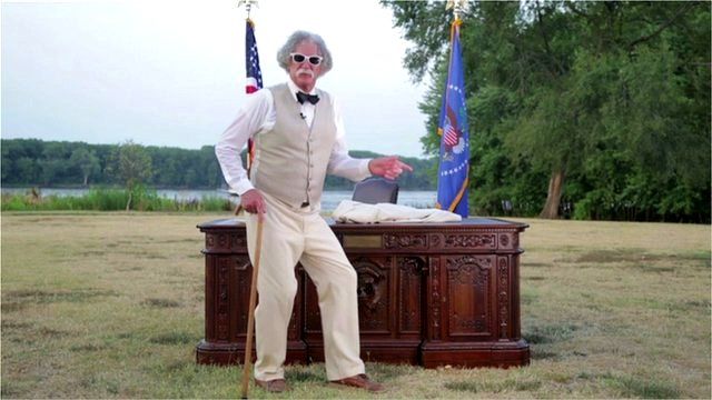 Old man in front of replica of Oval Office