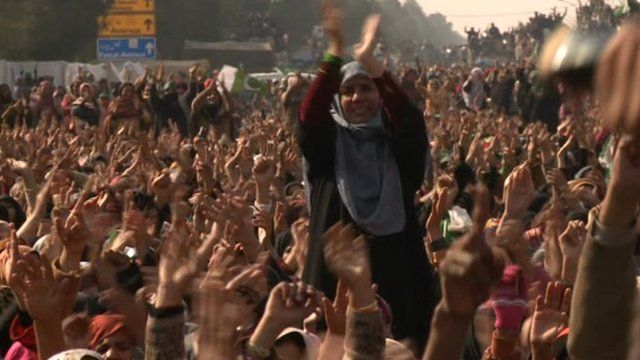 Woman sitting on shoulders of man in huge crowd