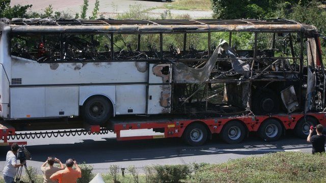 A damaged bus is being transported out of Burgas airport, Bulgaria
