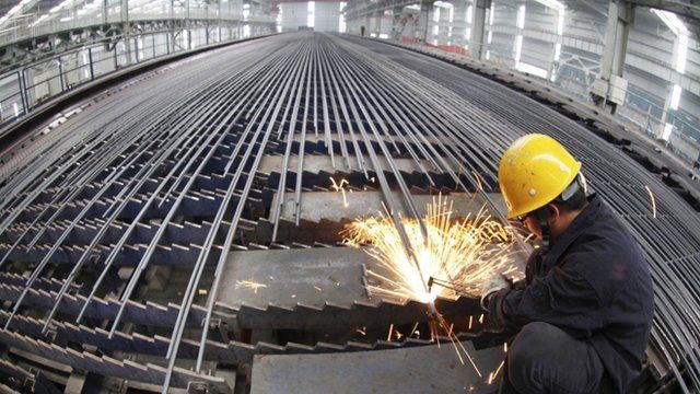 A worker cuts reinforcing bars in a steel factory in Ganyu county, Jiangsu province, China