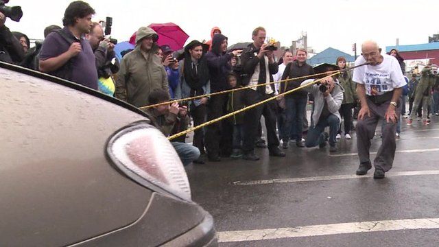 Strongman Mike Greenstein pulls a car with his teeth