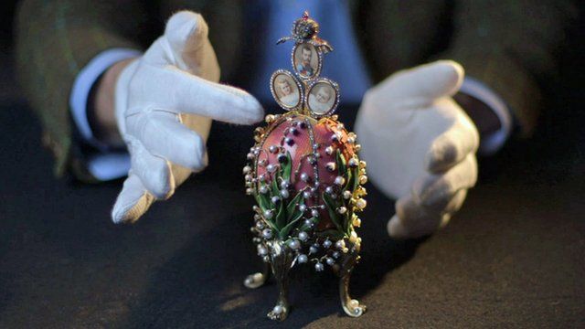 Gloved hands and a Faberge egg