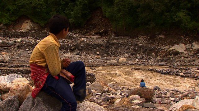 Boy and woman sitting near river
