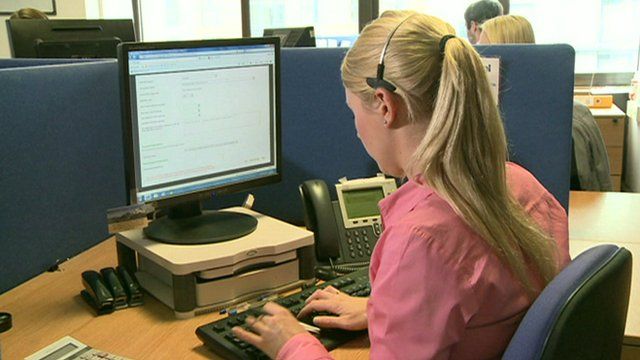 Woman entering insurance claim details into a computer
