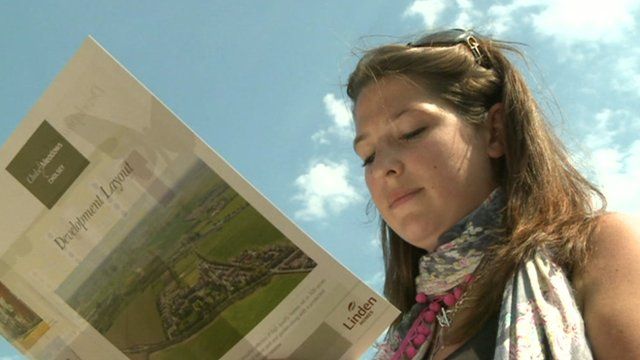 A homebuyer looks at plans for a property
