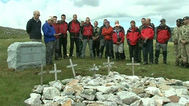 People gathered around a new granite memorial near Lochinver