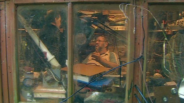 Radio enthusiast in shed full of equipment