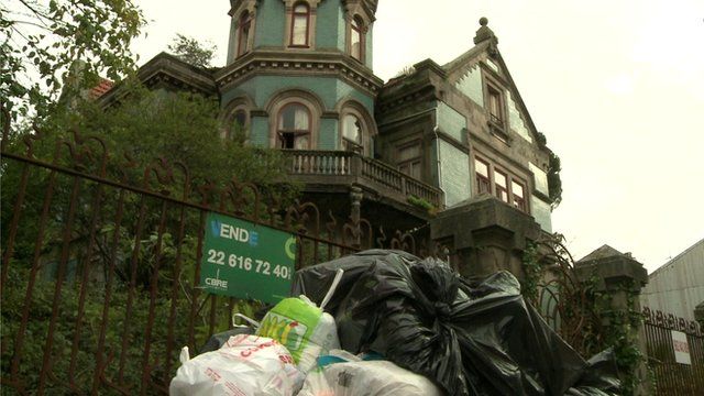 A derelict building with rubbish sacks