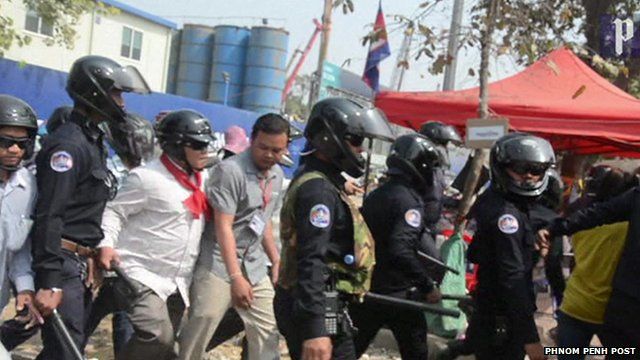 Police and civilians move in to clear the Phnom Penh park