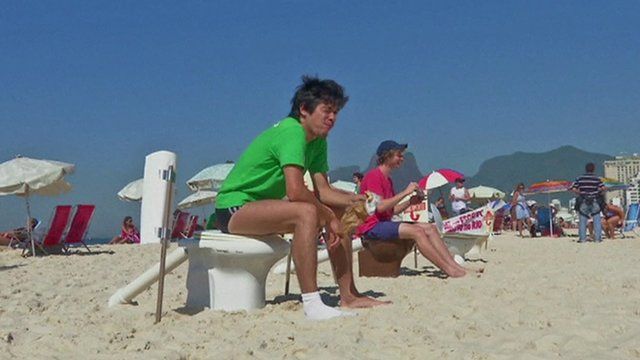 Campaigners sit on toilets on Ipanema beach