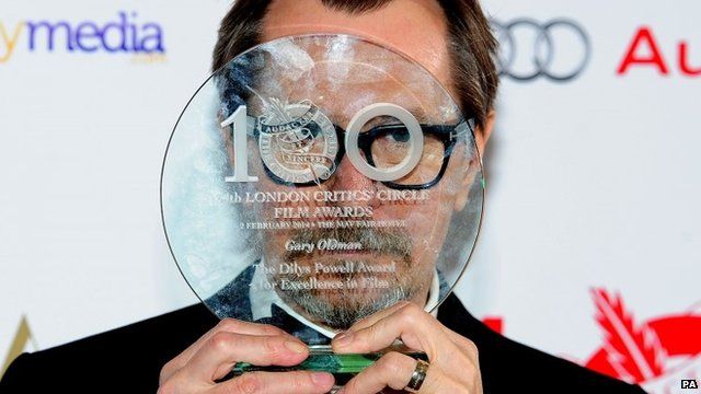 Gary Oldman hiding face with award