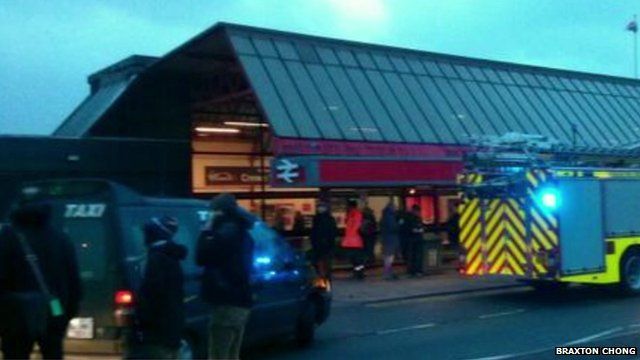 Emergency services and passengers outside Crewe station