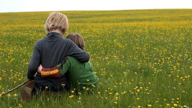 Children sitting in field - generic image