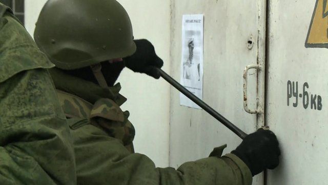Soldier using crowbar on door