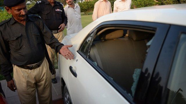 A Pakistani policeman points to a bullet hole