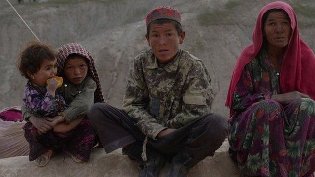 Afghan villagers look on at the scene in Argo district of Badakhshan province on May 3, 2014 after a massive landslide May 2 buried a village