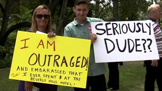 Protestors hold signs outside the Beverley Hills Hotel