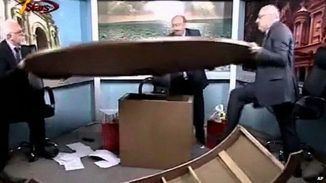 Journalists shoving broken desk