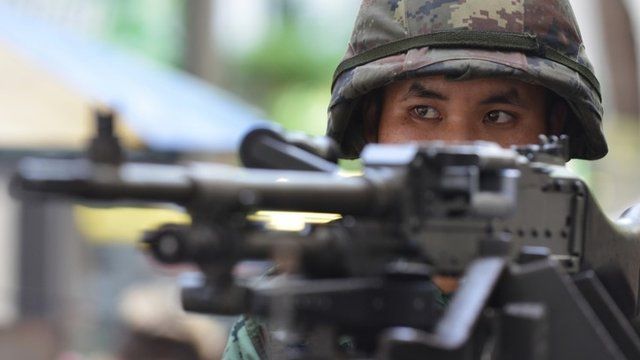 A Thai army soldier stands guard on a city centre street after martial law was declared on May 20