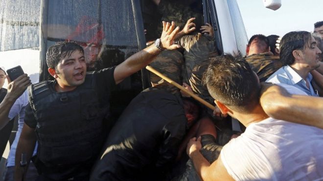 A policeman protecting soldiers following their surrender on Bosphorus Bridge in Istanbul