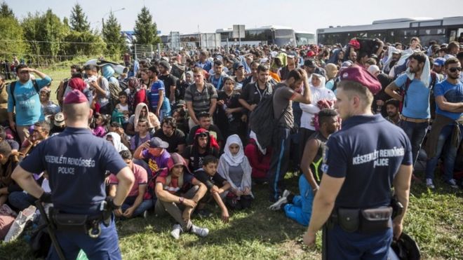 Hungarian police watch migrants at the Beremend crossing with Croatia, 18 Sept