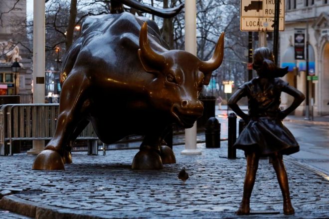 A statue of a girl facing the Wall St. Bull is seen, as part of a campaign by a US fund manager State Street to push companies to put women on their boards, in the financial district in New York