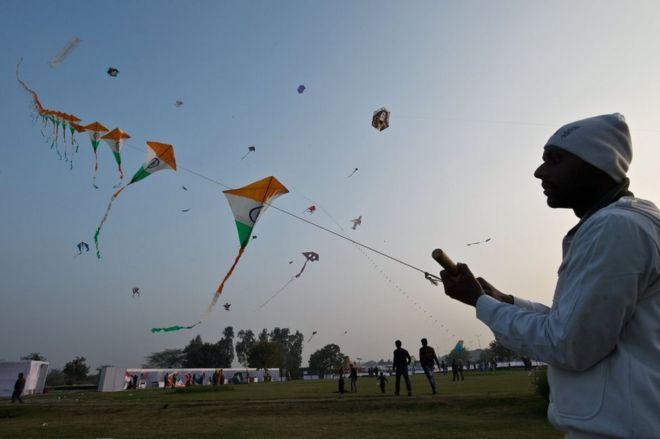 An Indian kite-flying enthusiast flies a hundred kites on a single string during the Delhi International Kite Festival at Golden Jubilee Park in New Delhi on January 24, 2014.