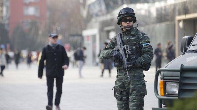 An armed policeman (R) of the Snow Leopard Commando Unit stands guard near a police van at the Sanlitun area, a fashionable location for shopping and dining, in Beijing, China, December 24, 2015