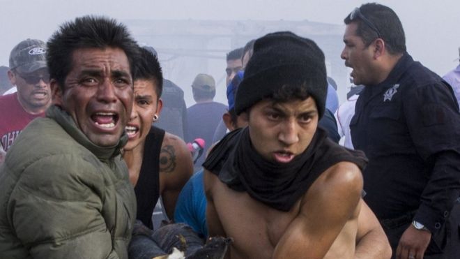 Hombres ayudan a heridos de la explosión en Tultepec
