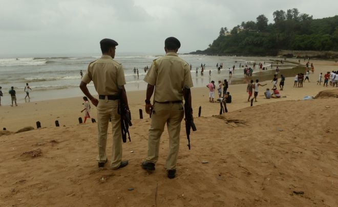 Indian policemen stand guard as they watch over tourists visiting Baga beach in Goa on September 24, 2016.
