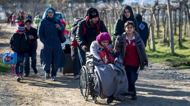 Migrants cross the Greek-Macedonian border near the town of Gevgelija on 25 February 2016