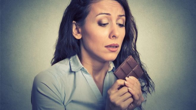 Mujer tentada de comer chocolate