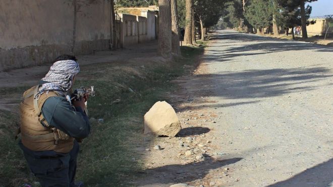 An Afghan policeman takes position during fighting between Taliban militants and Afghan security forces in Kunduz on October 3, 2016.