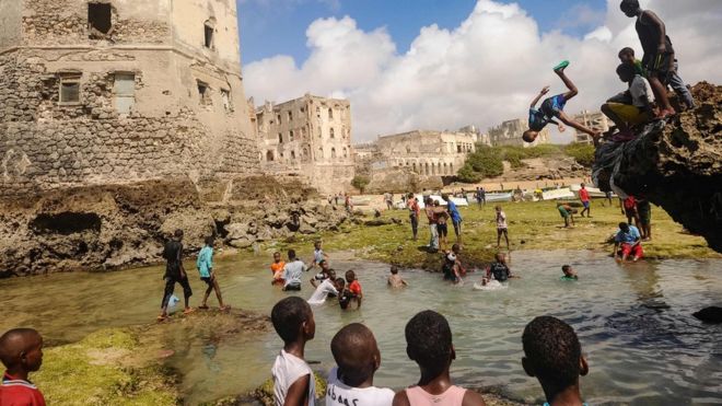 Somali children dive, play and swim in front of the ruins of an old building on the coastal district of Hamarweyne, in Mogadishu on Friday.