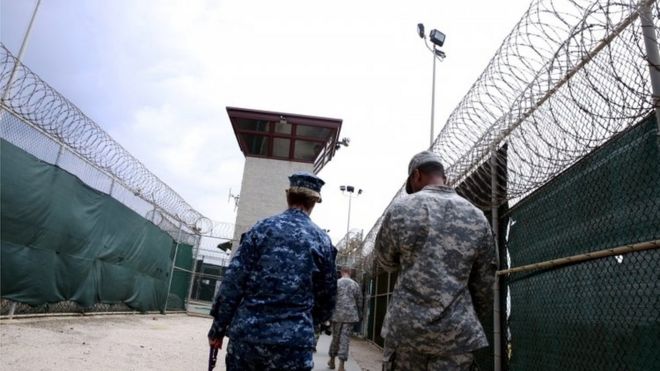 A US Navy sailor (left) walks with soldiers in Joint Task Force Guantanamo's Camp VI in Guantanamo Bay. Photo: March 2016