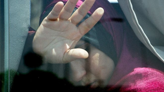 A relative of a passenger on an EgyptAir flight that crashed early Thursday puts her hand on the window from inside a bus at Cairo International Airport, Egypt, Thursday, May 19, 2016.