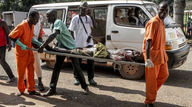 A wounded man is carried into the General Hospital in Bangui on September 26, 2015 after unknown assailants opened fire in the PK5 district, a neighbourhood with a majority of Muslim residents.