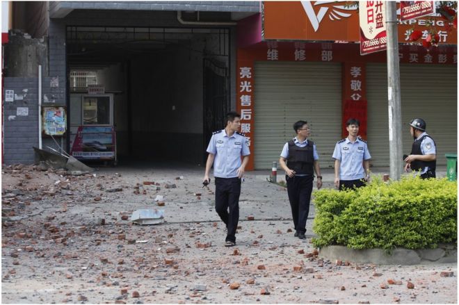 Police investigators inspect the area around a damaged building a day after a series of blasts in Liucheng county in Liuzhou, south China"s Guangxi province on 1 October 2015.