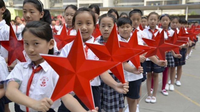 Students pose with red stars during an event to mark the 70th anniversary of the Victory of Chinese People