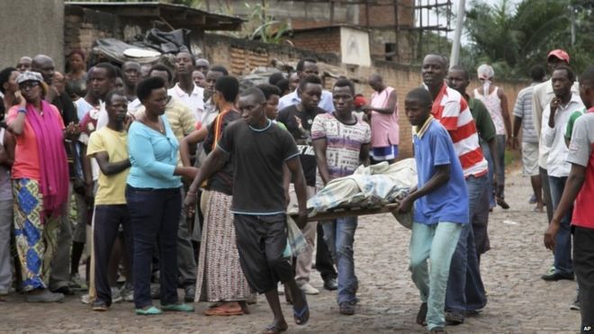 Men carry away a dead body in the Nyakabiga neighborhood of Bujumbura