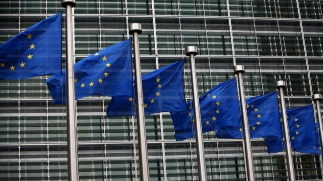 EU flags waving outside European Commission building in Brussels