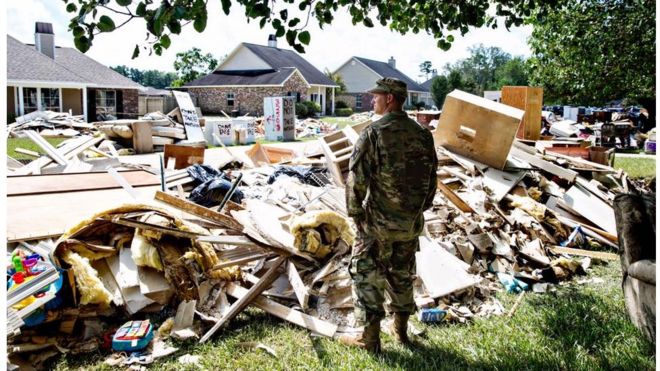 Chris Daves, a National Guardsman, surveys the damage from a friend's yard. He's there to help and listen, "We're fellow Army men, that's what we do." Watson, LA.