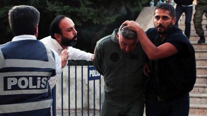 A civilian, 2nd left, spits at a member of Turkey armed forces as he is escorted by police for suspected involvement in Friday's attempted coup at the court house in Mugla, a Mediterrenean city of Turkey (July 17, 2016)