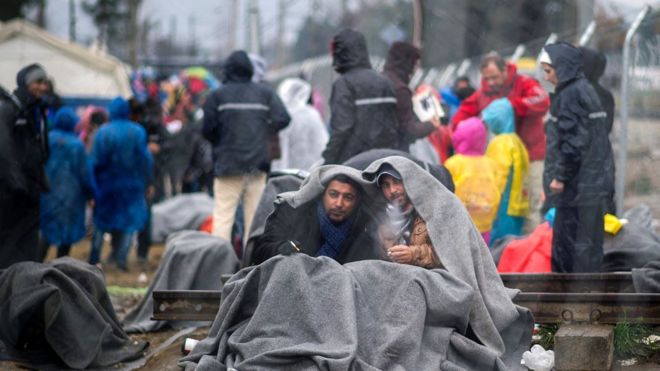 Migrants from Syria wait to cross the Greek-Macedonian border near the town of Gevgelija on February 24, 2016