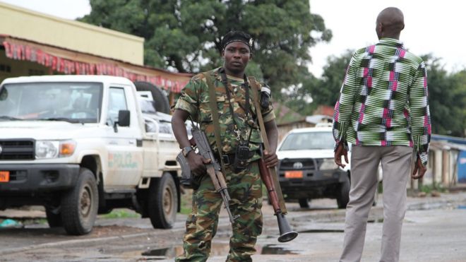 A Burundian soldier with his gun and rocket launcher guard a deserted street in Bujumbura